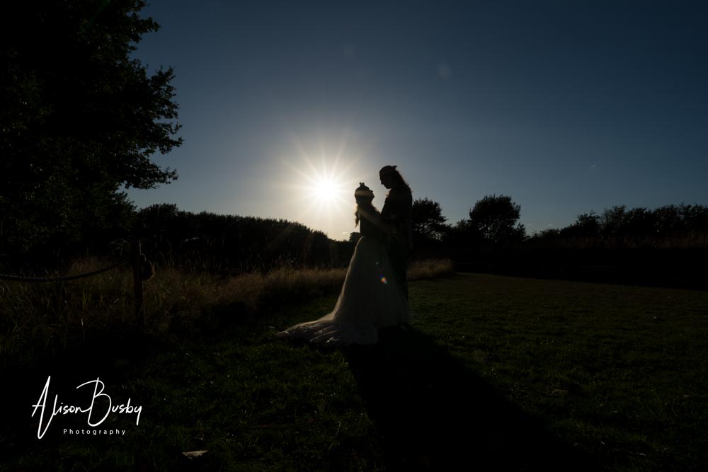 Buckinghamshire woodland wedding photographer. bride and groom silhouette next to lake.