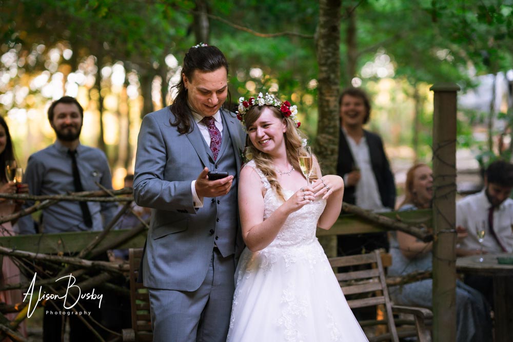 Buckinghamshire woodland wedding photographer. Wedding party around firepit at sunset. Endeavour Woodland Weddings.