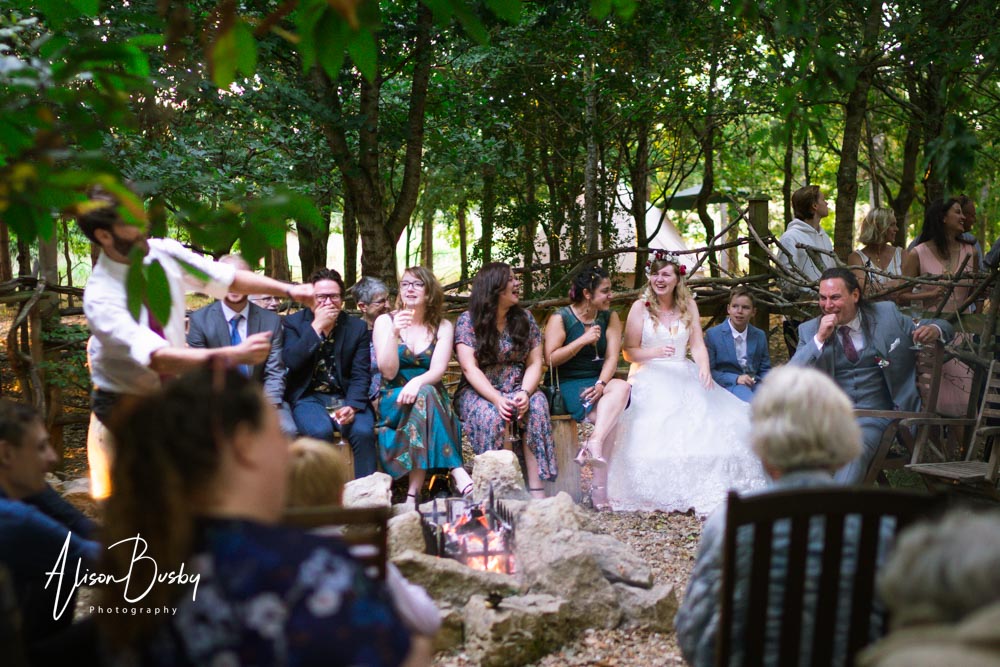 Buckinghamshire woodland wedding photographer. Wedding party around firepit at sunset. Endeavour Woodland Weddings.