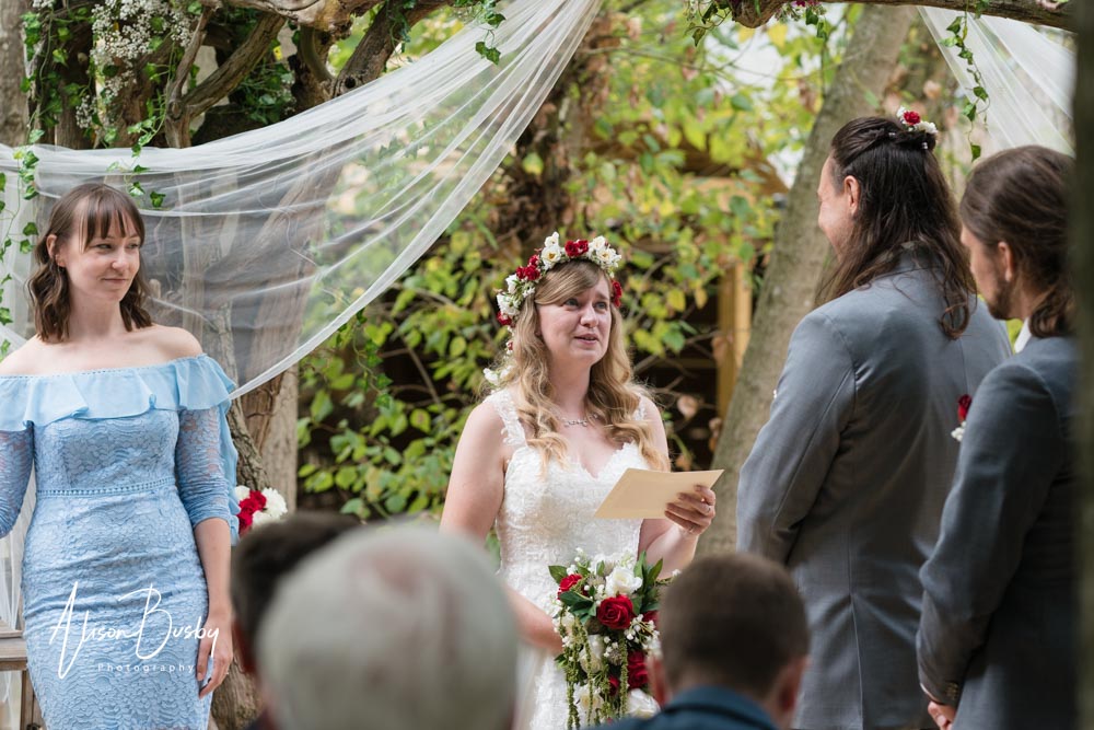 Buckinghamshire woodland wedding. Bride and groom exchange vows under the tree arch at Endeavour Woodland Weddings.