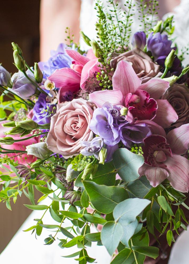 Bride holding pink bouquet by professional wedding photographer.