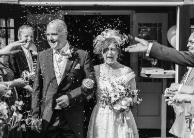 Bride and groom in Confetti tunnel at Kings Chapel