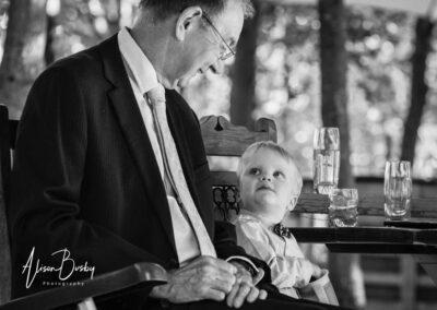 Grand father looking at grand son at Buckinghamshire woodland wedding
