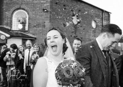 Bride and groom in confetti tunnel at Kings Chapel