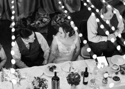 Bride and groom look at each other during wedding breakfast at Kings Chapel in Amersham