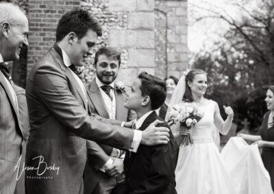 Groom speaking to young boy at Lacey Green wedding