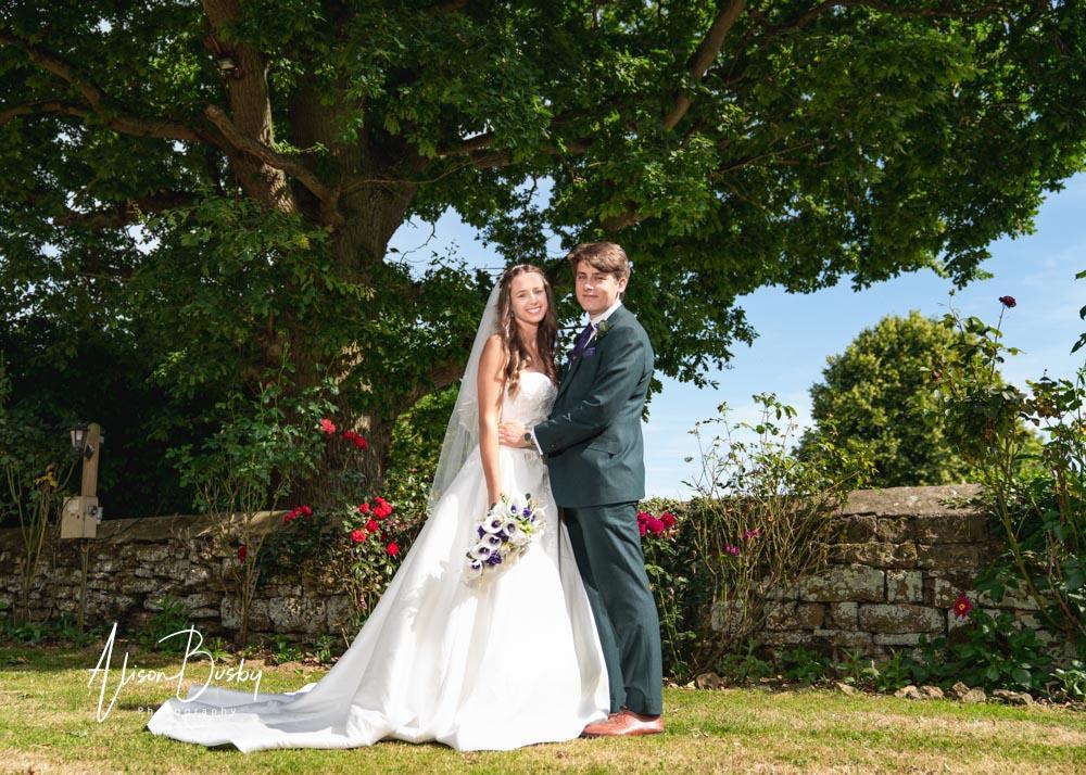 Bride and groom in grounds by Dovecote Events Wedding Photographer