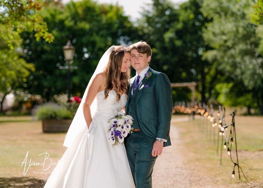 Bride and groom in grounds by Dovecote Events Wedding Photographer