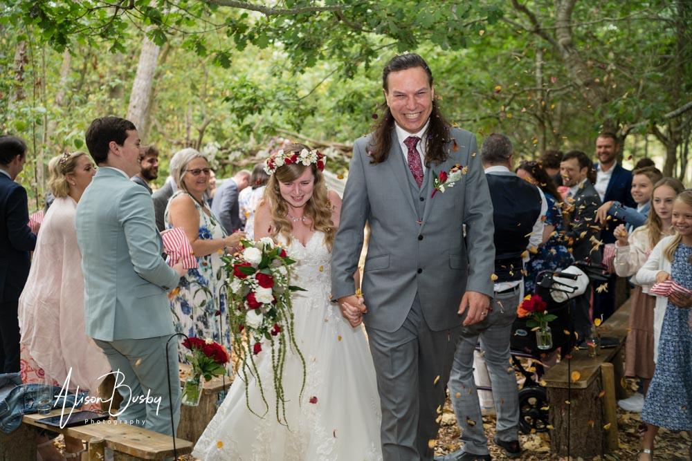 Bride and groom in confetti tunnel by Dovecote Events Wedding Photographer