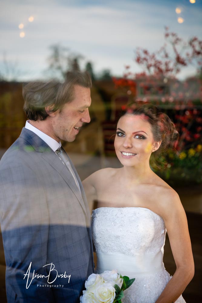 Couple with window reflection at Eynsham Hall in Oxfordshire