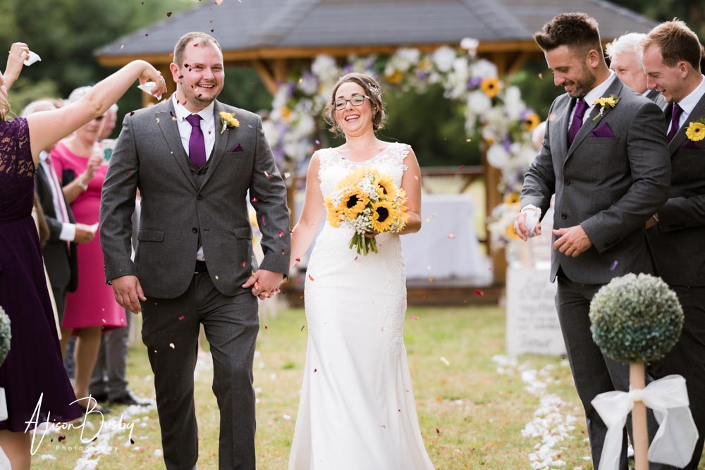 Bride and groom in confetti at Grovefield House wedding. Outdoor wedding