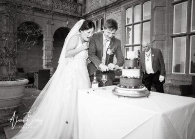 Bride and groom cut cake at Eynsham Hal wedding