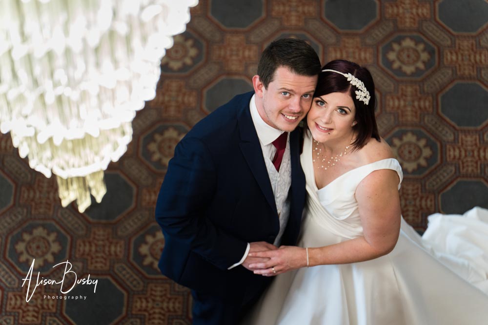 The Oxfordshire wedding photographer. Bride and groom under chandelier