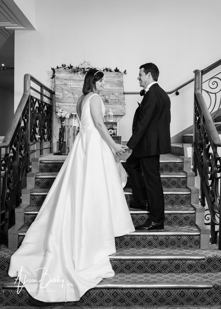 The Oxfordshire wedding photographer. Bride and groom on staircase in black and white