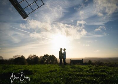 Buckinghamshire engagement shoot at Brill Windmill. LGBT engagement photos. Silhouette of two women with windmill blade.