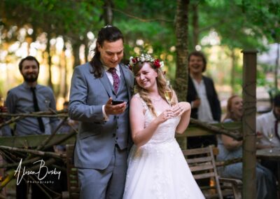 Buckinghamshire woodland wedding. Bride and groom with guests around fire pit at Endeavour woodland weddings.