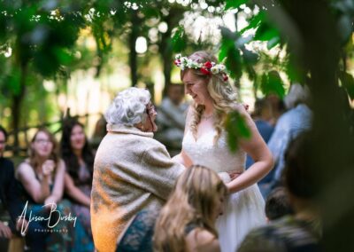 Buckinghamshire woodland wedding. Bride with grand mother next to fire pit at Endeavour woodland weddings.
