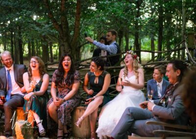 Buckinghamshire woodland wedding. Bride and groom with guests around fire pit at Endeavour woodland weddings.