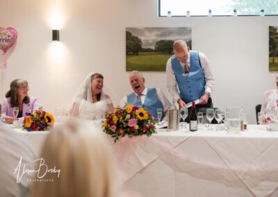 Older Couple wedding photographs. Bride and groom laughing during best man's speech.