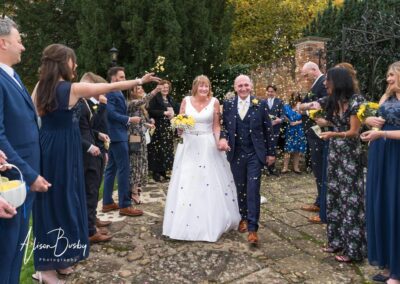 Older Couple wedding photos. Bride and groom under confetti tunnel.