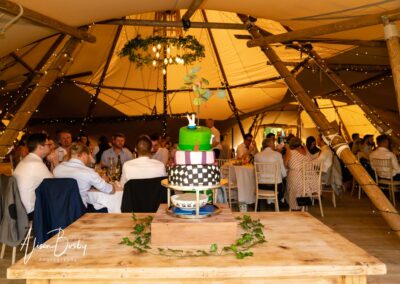 Oxfordshire tipi wedding at Dovecote Events. Wedding cake and guests.