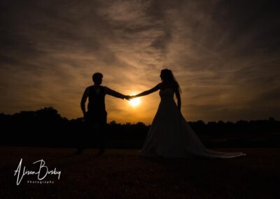 Oxfordshire tipi wedding at Dovecote Events. Bride and groom sunset silhouette.