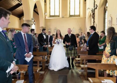 Bride walks down aisle at Our Lady and St Edmunds Church in Abingdon, Oxfordshire.