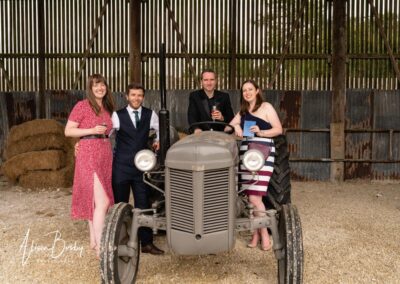 Wedding guest portraits. Two couples with farm equipment at Sheepdrove Organic Farm in Berkshire