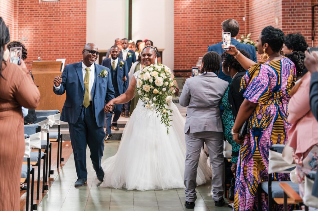 Berkshire wedding photographer. Bride and groom dance out of church in Reading.