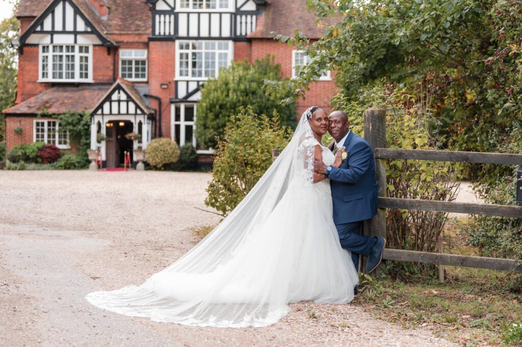 Berkshire wedding photographer. Bride and groom embrace at entrance to Trunkwell House in Reading
