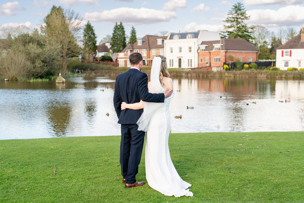 Bride and groom at Latchmoor pond after wedding at the Bull Hotel in Gerrards Cross
