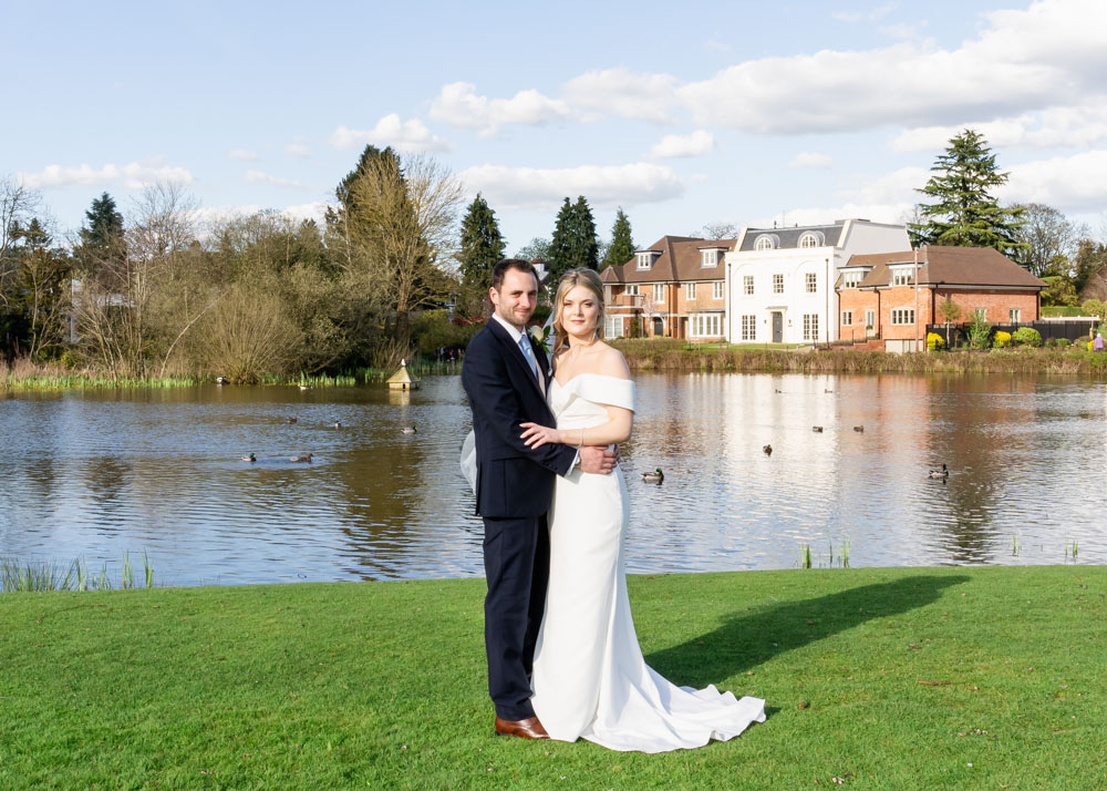 Bride and groom at Latchmoor pond after wedding at the Bull Hotel in Gerrards Cross