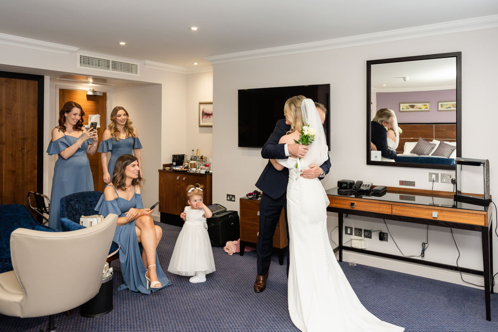 Father of the bride embraces his daughter at the Bull Hotel in Gerrards Cross