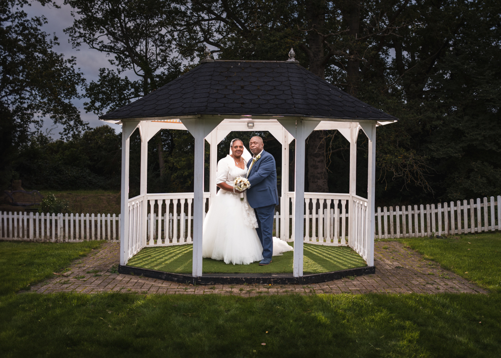 Bride and groom in gazebo at Trunkwell House wedding in Berkshire.