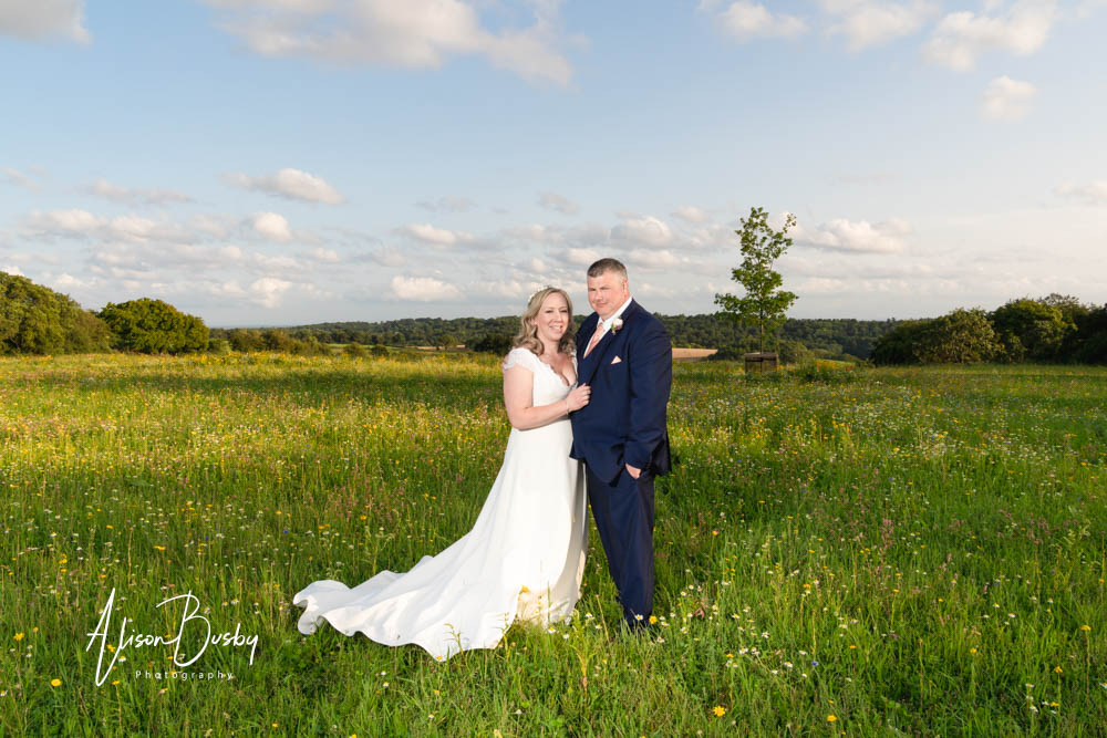 Sunset wedding photo of bride and groom in wild flower meadow at Rackleys Chiltern Hills in Buckinghamshire