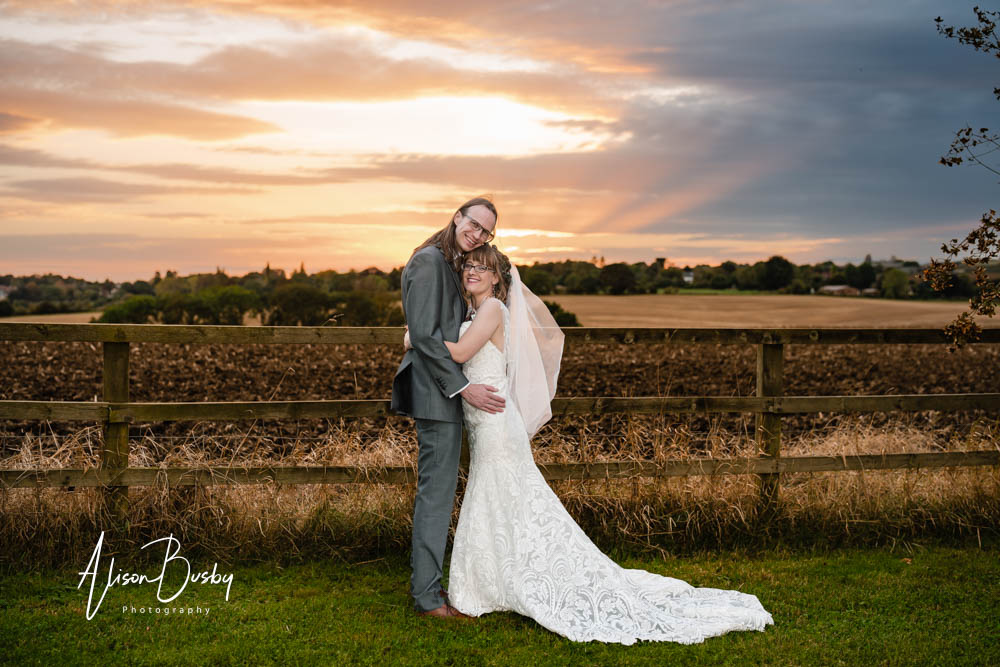 Sunset wedding photo of bride and groom at Notley Tythe Barn