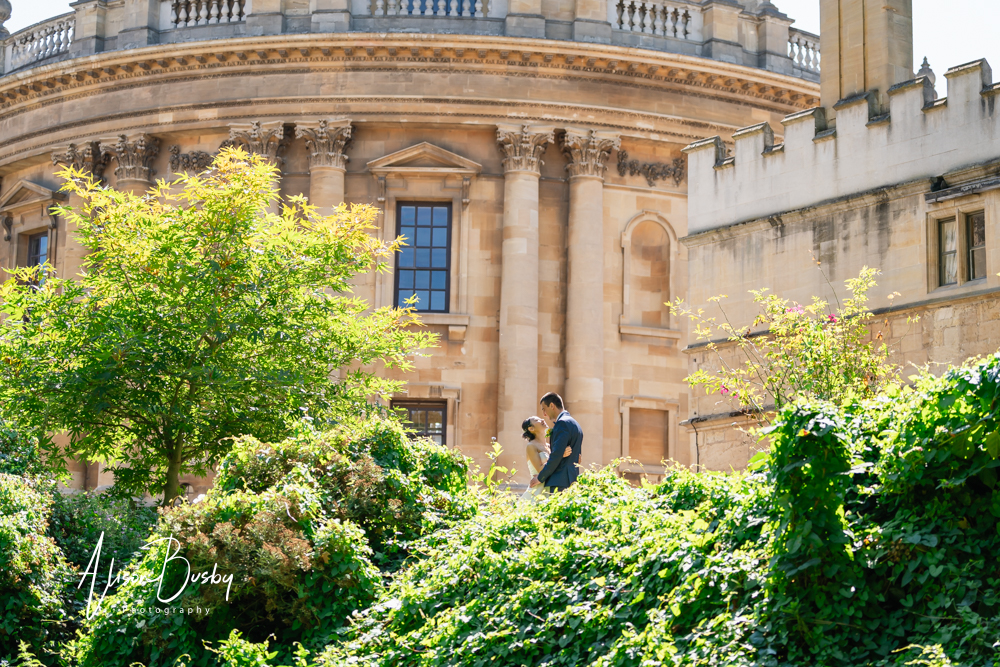 Bride and groom next to Radcliffe Camera on viewing platform in Fellows Garden Exeter College at their Oxford wedding