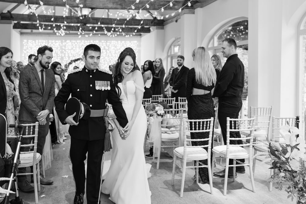 Dorney Court wedding photographer. Bride and groom leaving ceremony in the barn at Dorney Court near Eton in Berkshire.