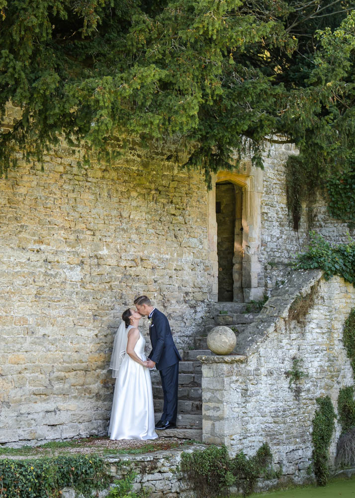 Oxfordshire wedding Le Manoir aux Quat’Saisons. Bride and groom on the steps next to the pond.