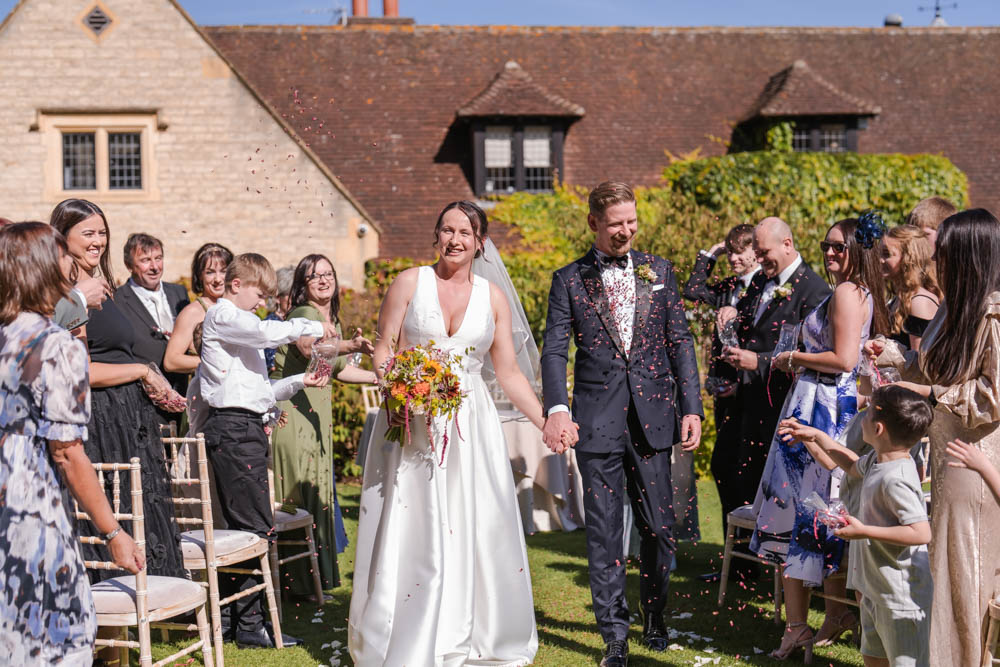 Oxfordshire wedding Le Manoir aux Quat’Saisons. Bride and groom in confetti tunnel
