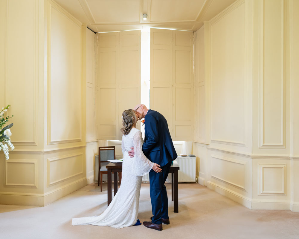 Shaw House weddings. Bride and groom exchange first kiss after ceremony at Shaw House in Newbury Berkshire.