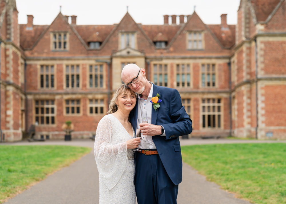 Shaw House weddings. Bride and groom toast in front of Shaw House in Newbury Berkshire.
