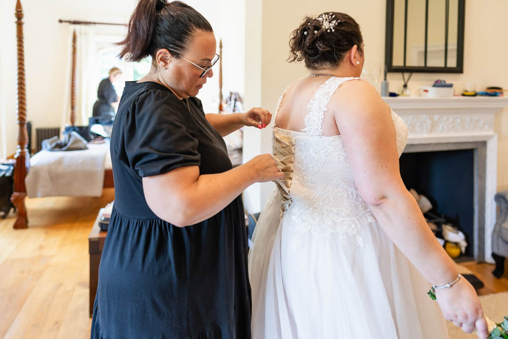 Notley Abbey bridal prep. Fastening the dress