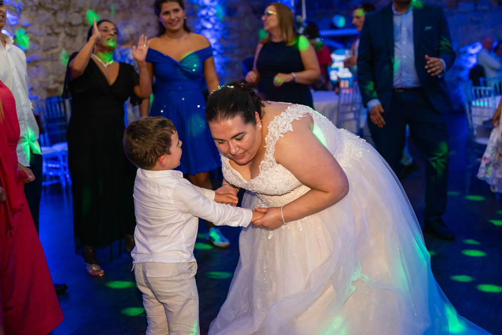 Notley Abbey wedding photographer. Bride with a young guest in the Monks refectory.
