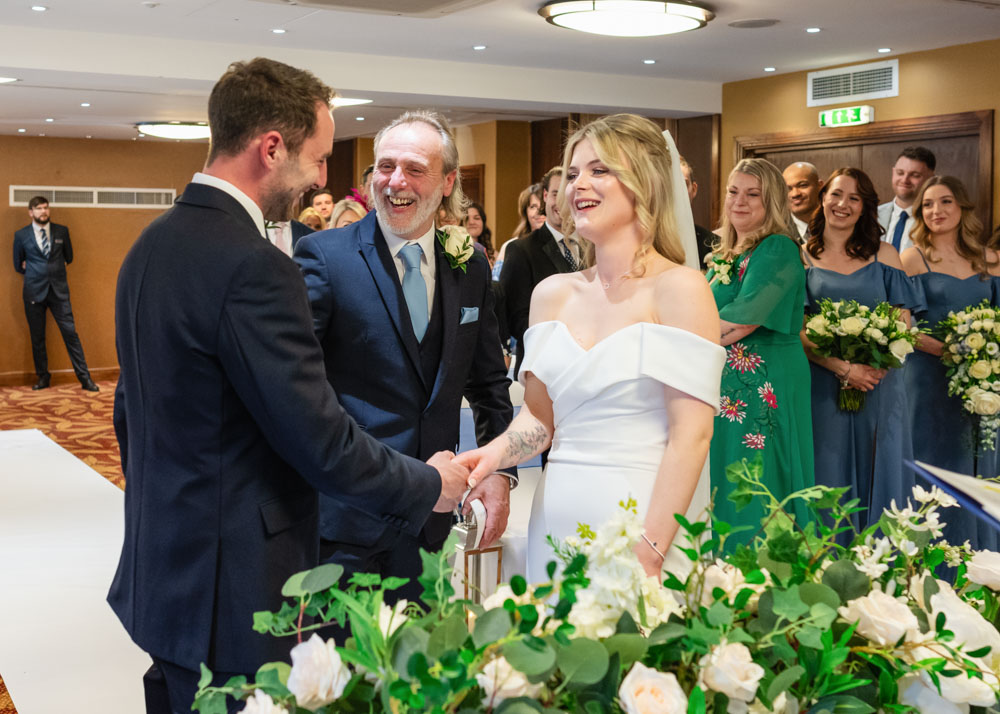 Father of bride giving daughter's hand at Bull Hotel wedding