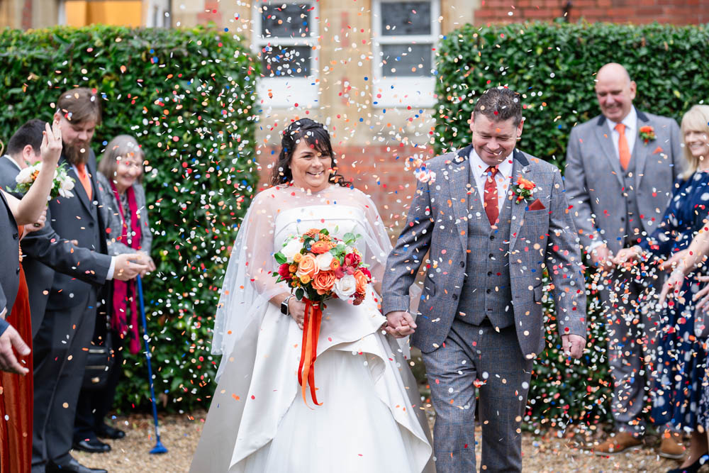Cantley House wedding photographer. Bride and groom in confetti tunnel at Cantley House, Berkshire