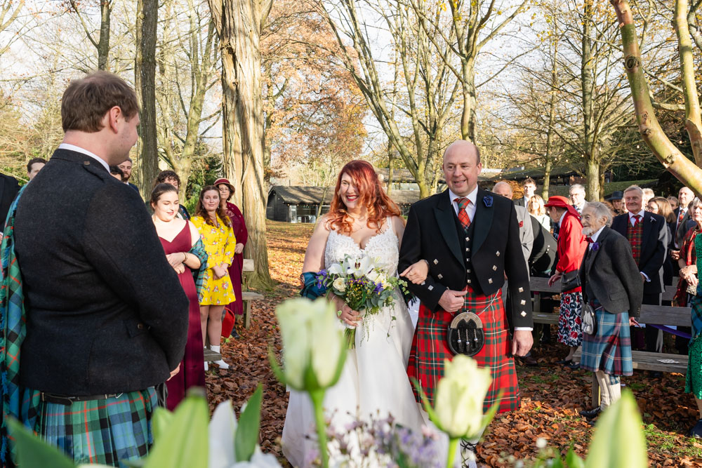 Bride and father arriving for outdoor wedding ceremony at the Garden House Venue in Steventon, Oxfordshire