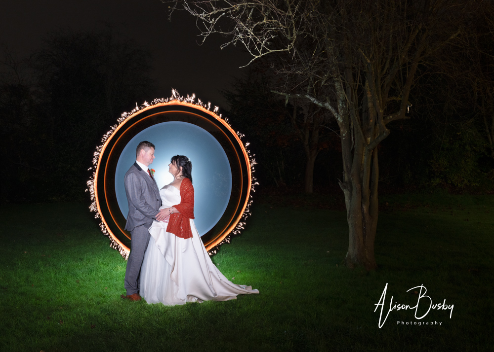 Nighttime wedding photograph of bride and groom with light painting and sparklers