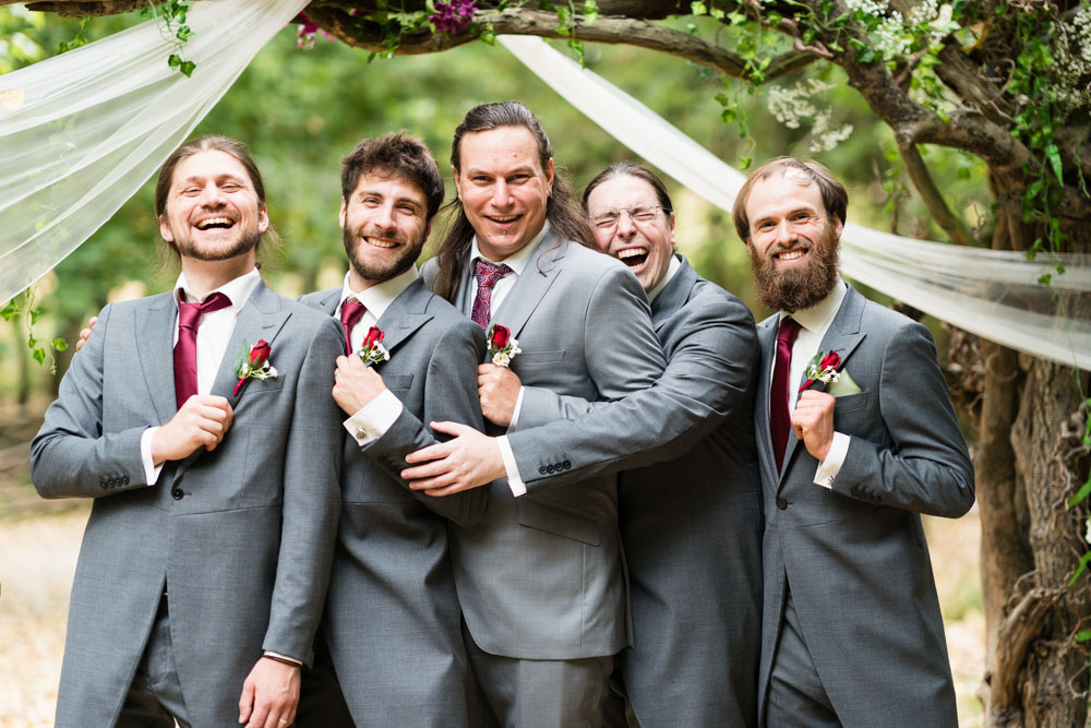 Wedding photography buckinghamshire. groomsmen laughing in woodland
