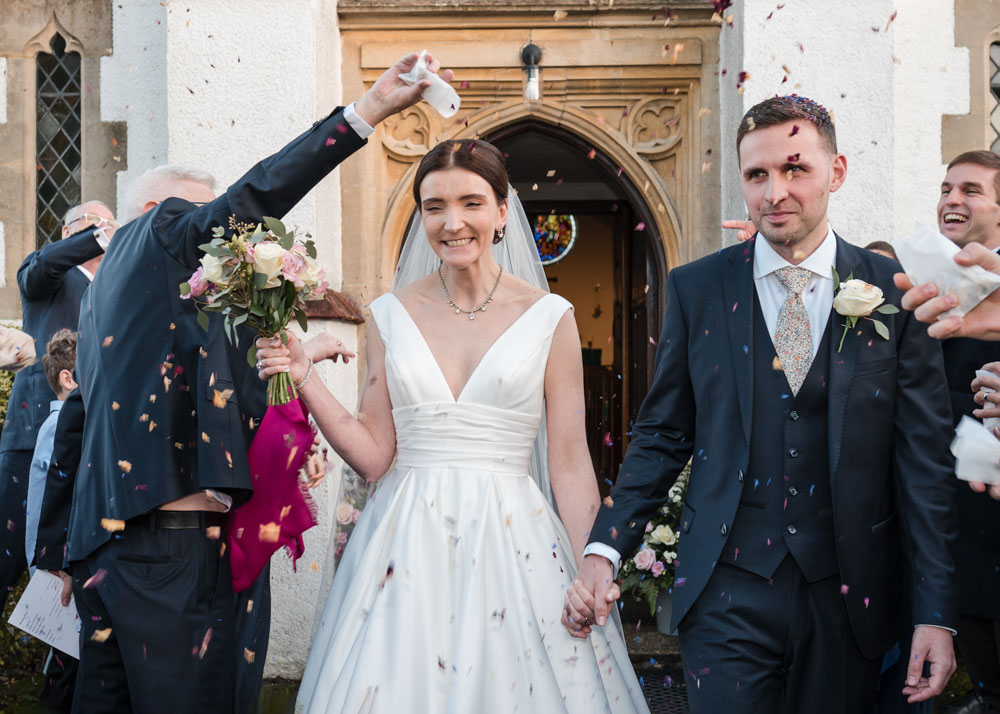 Wedding photography kings chapel amersham. bride and groom in confetti tunnel